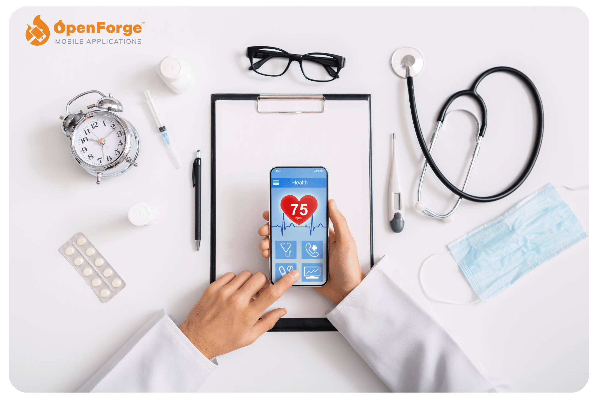 Top view of a healthcare professional’s workspace, featuring essential medical items such as a stethoscope, alarm clock, clipboard, eyeglasses, thermometer, and a face mask. The focus is on a smartphone held by a doctor displaying a health app with a heart rate of 75 bpm, underscoring the integration of mobile technology in health monitoring. This setup illustrates the use of mobile applications in daily medical practices, presented by OpenForge.